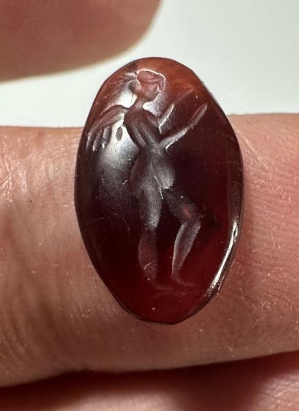Picture of Greco-Roman stone intaglio. 1st century BC/AD. 16 x 10 mm. Incuse winged Nike standing r., extending both arms.